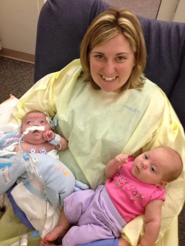 Kid Captain Lily Sebastian and her twin sister Gemma being held by their mother