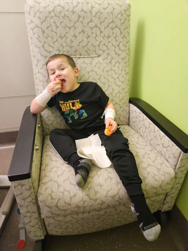 Kid Captain Micah Norby sitting in a hospital bed