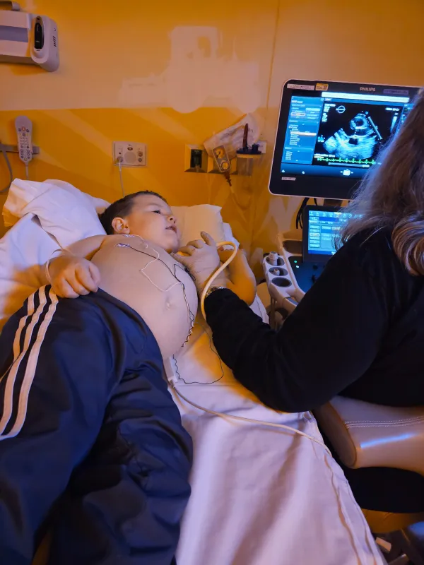 Kid Captain Micah Norby lying on a hospital bed while being examined