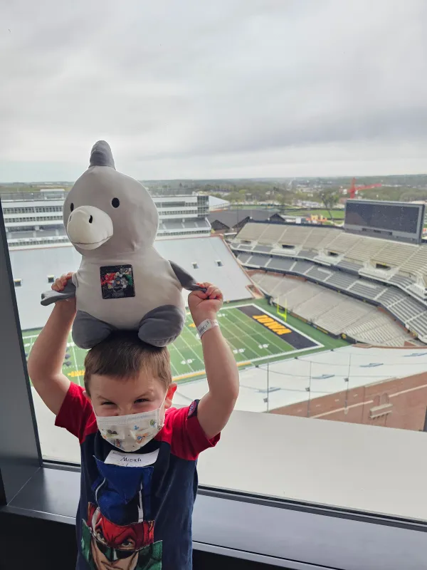 Kid Captain Micah Norby at Stead Family Children's Hospital standing in front of a window