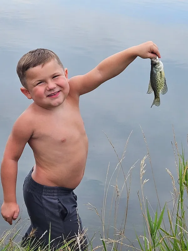Kid Captain Micah Norby holding a fish