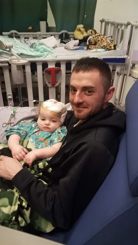 Kid captain Ray Walker being held by father