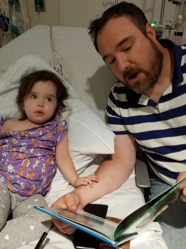 Kid Captain Millie Judge and father reading her a book