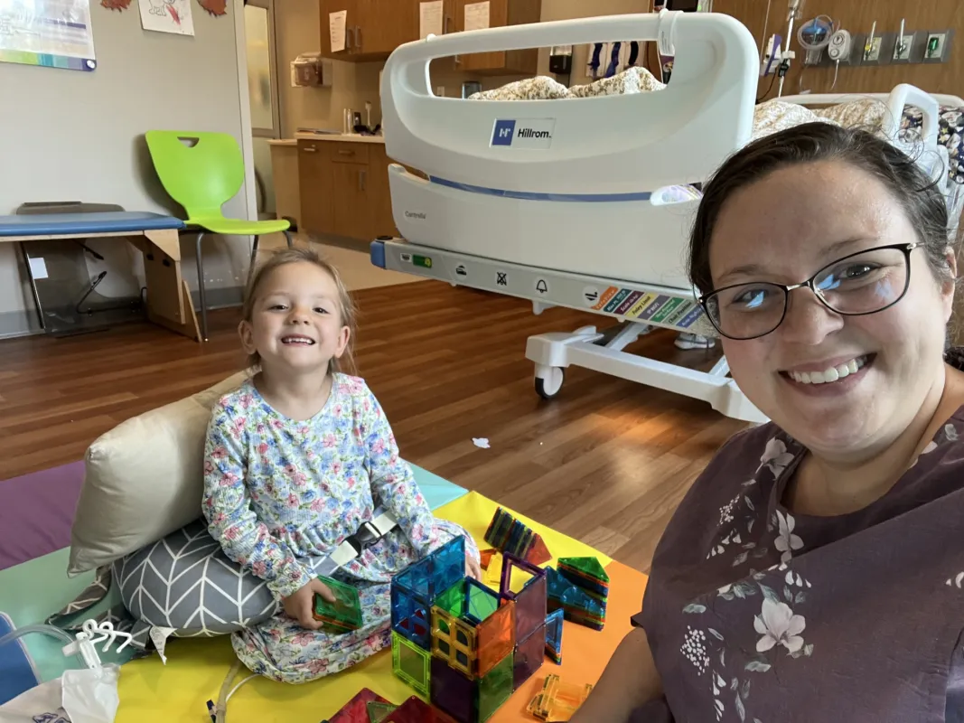 Raegan playing with toys in her hospital room