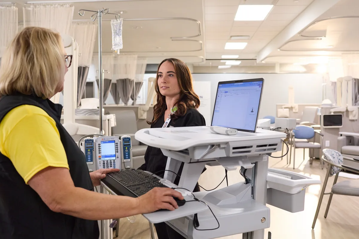 Mission Cancer + Blood employees in front of a workstation
