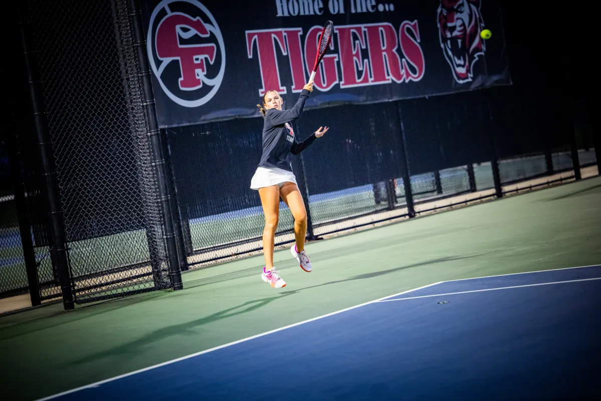 Mackenzie Sagers jumping to hit a tennis ball