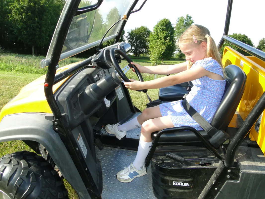 Young girl in an UTV gripping the steering wheel