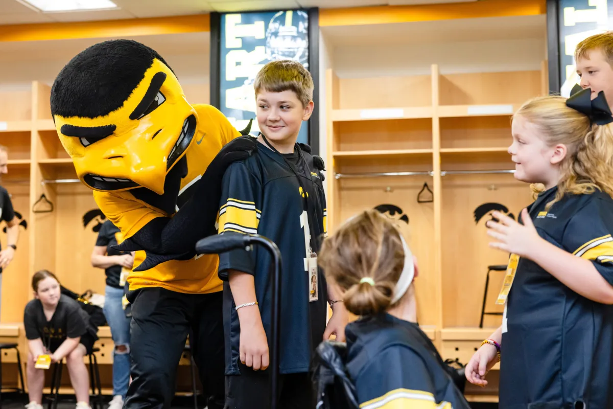 Charlie Price with Herky in the Iowa Football locker room. 