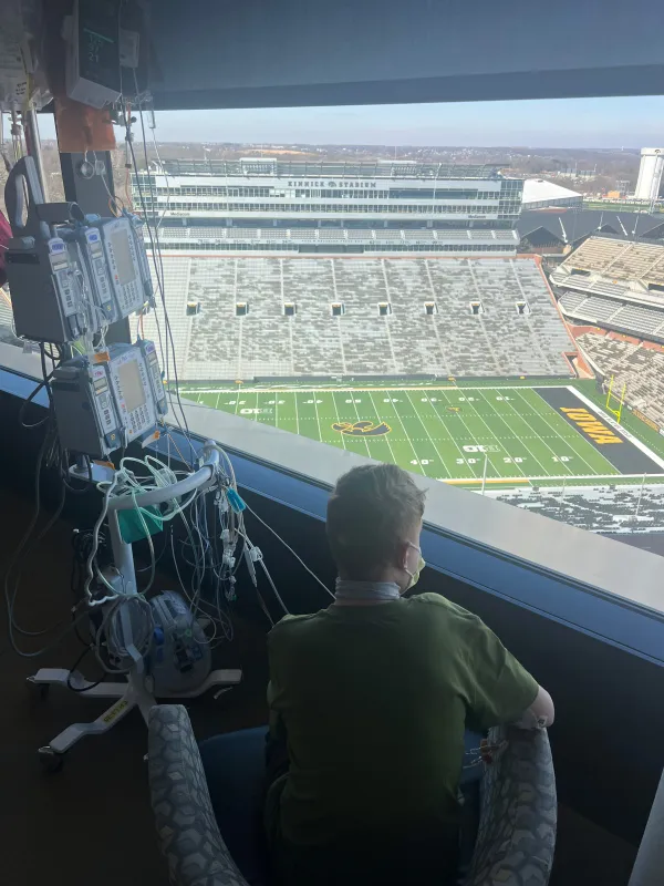 Kid Captain Beau Harvey looking out a window over Kinnick Stadium