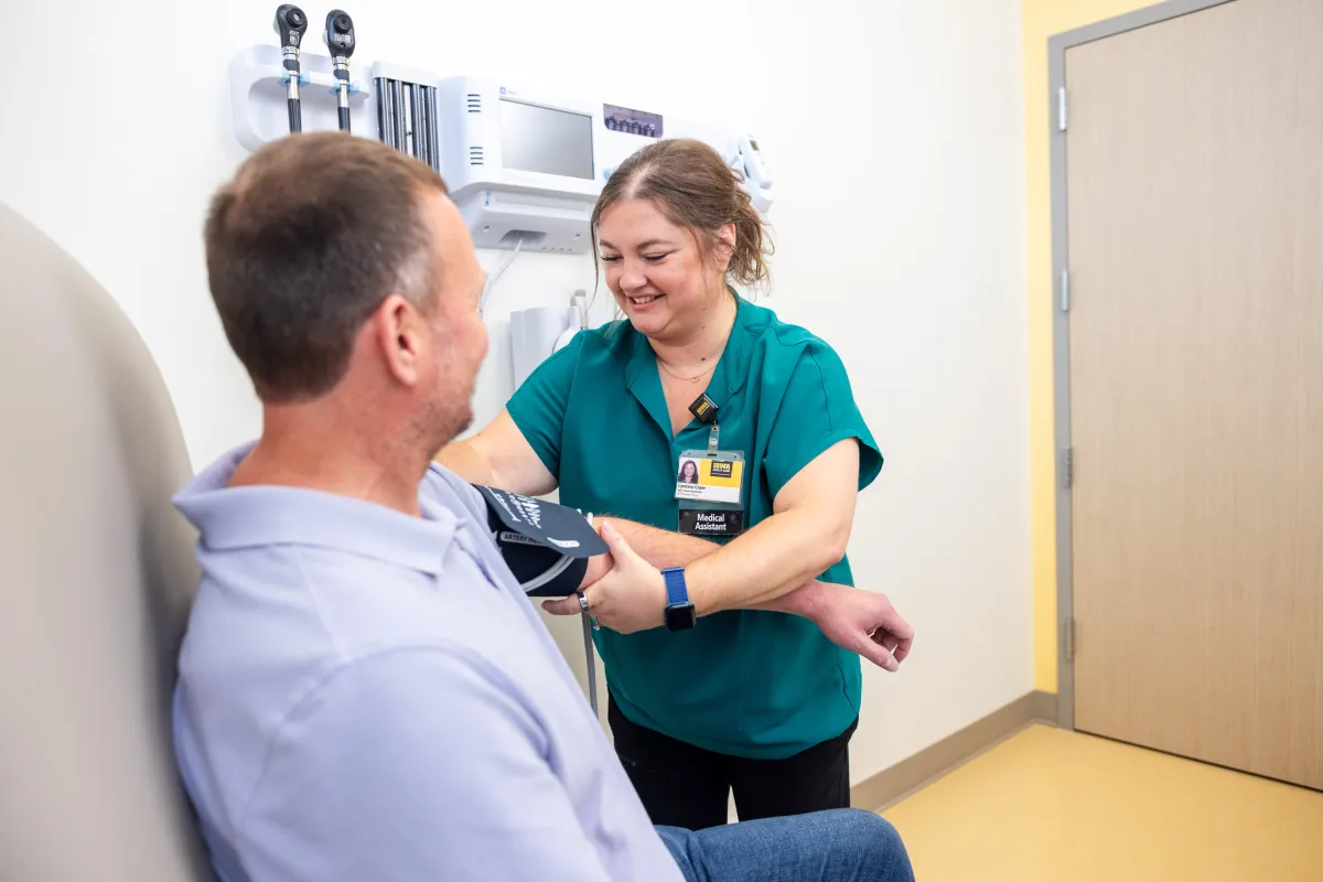 Medical assistant takes blood pressure of simulated patient