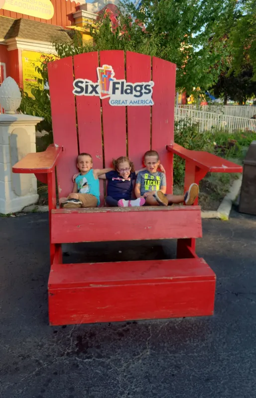 Kid Captain Eliana Gaul sitting on a large chair with her brothers