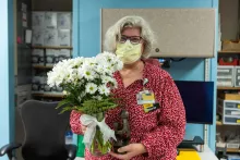 Barb Schuessler with a bouquet of daisies