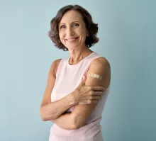 Stock photo of an elderly woman with a bandaged arm after vaccination