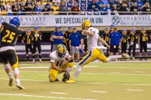 Dubuque Wahlert senior Nathan Schiesl kicking a field goal during a football game