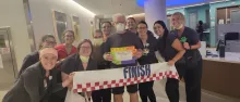 Steve Pruisner with nursing team with finish line banner