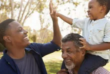 A stock photo of a dad and son high fiving.