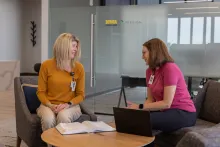 Two women sitting down discussing clinical trials