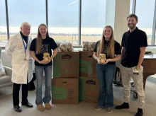 Meredith Secymore and Addy Blade with there providers Stuart Weinstein, MD, and Joshua Holt, MD, presenting teddy bear gift.