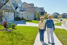 Holding hands, walking and elderly couple in neighborhood for fresh air, wellness and active in morning. Retirement, marriage and happy senior man and woman on sidewalk for bonding, love and health