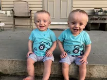 Colby and Connor Gerlach sitting outside on a stoop