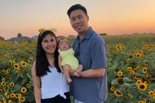 Michael and Tina Lung hold their daughter, Makayla Lily Lung, outside by a field of sunflowers