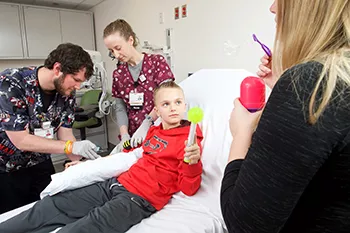 Child using bubbles and toy for distraction in action