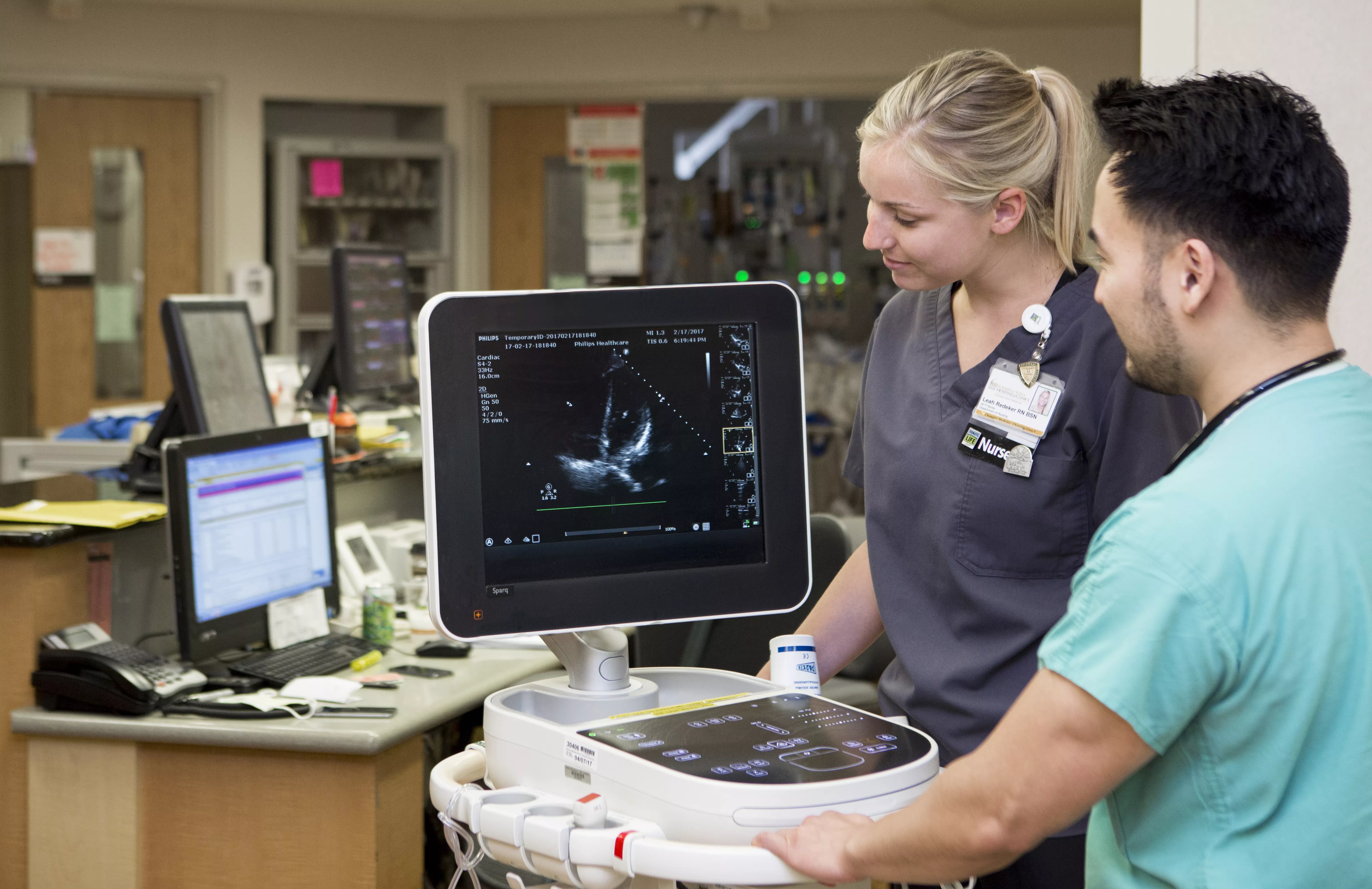 Two nurses examining patient condition via monitor