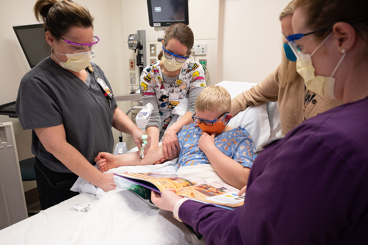 Nurses and medical staff placing an IV for a child using J-tip for numbing