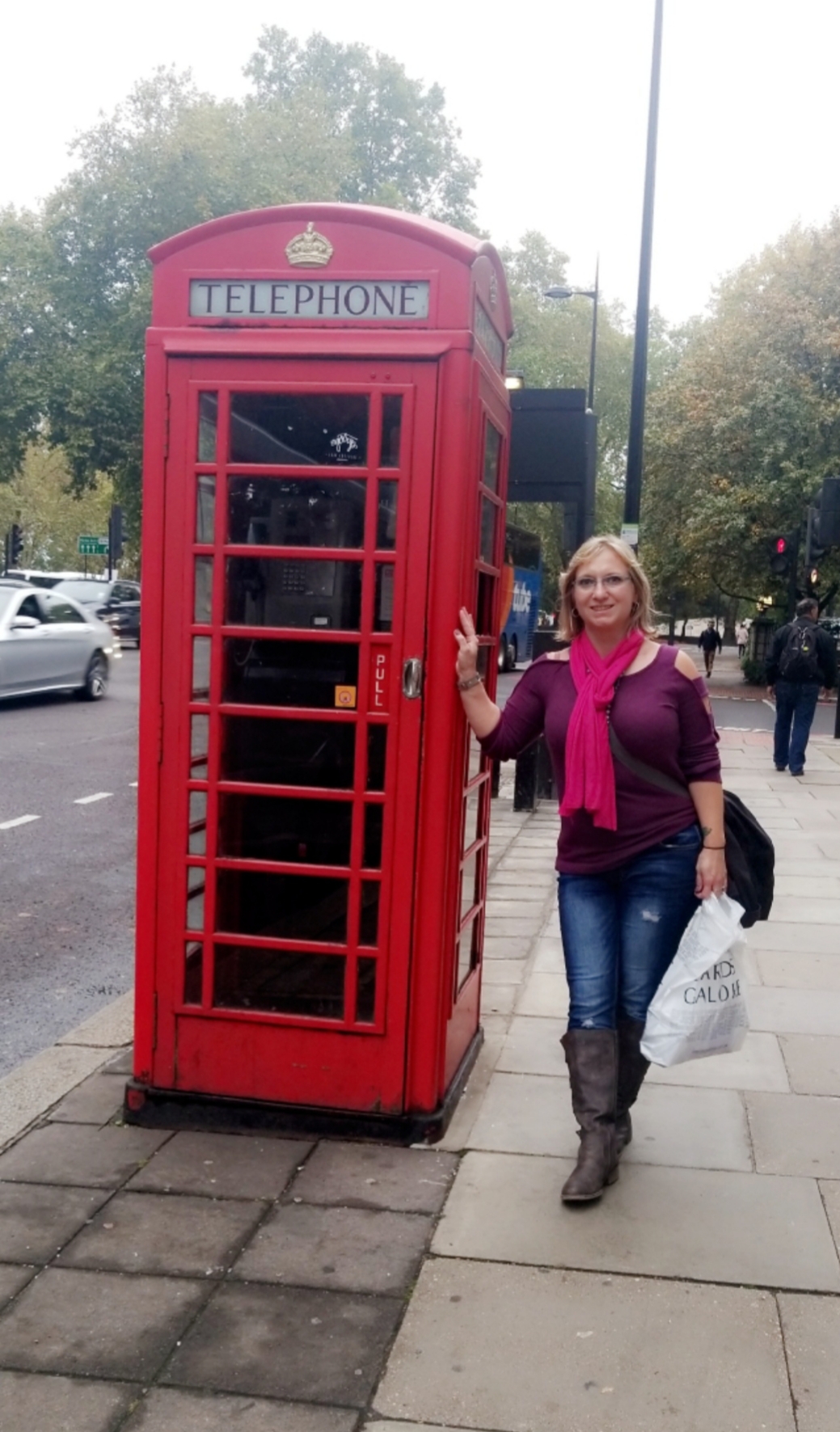 Lynnita Truesdell stands next to a telephone booth while traveling abroad