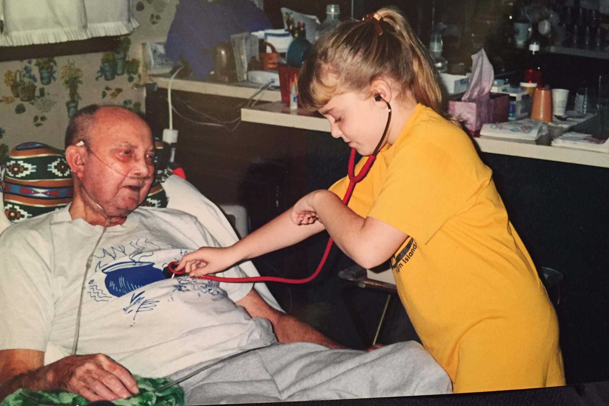 Marisa Weaver as a child, listening to her grandfather's heart with a stethoscope